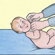 Säugling richtet sich mithilfe Anderer in aufrechte Position auf. 