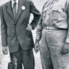 JULIUS ROBERT OPPENHEIMER mit General LESLIE R. GROVES, dem verantwortlichen Militär für den Bau der Bombe, am Rand des Kraters der Versuchsexplosion in der Wüste von New Mexico (1945) 